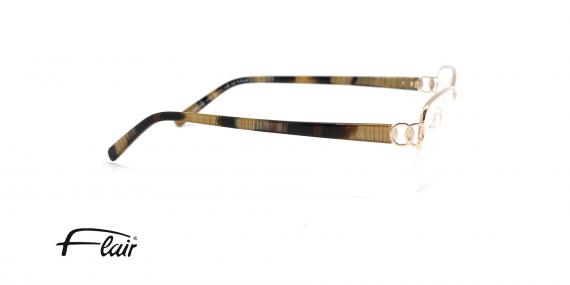 عینک طبی تیتانیومی فلر فریم زیر گریف طلایی و خدقه های بیضی شکل - عکس از زاویه کنار