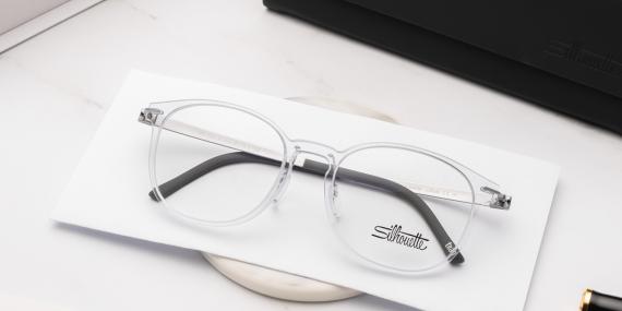 عینک طبی سیلوئت مدل SPX فریم دایره ای به زنگ شفافا و دسته های تیتانیومی - عکس عینک همراه جلد